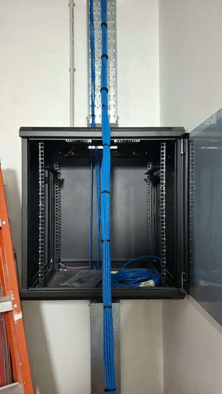 Paquete de cables azules llegando al rack desde la bandeja